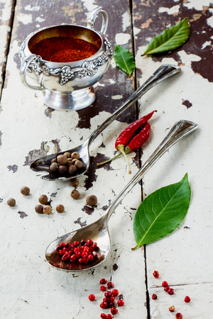 Collection of spices selection in vintage metal spoons and cup over old wood background.の写真素材