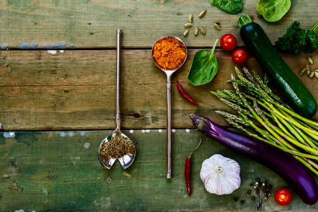 Herbs and ingredients on old wooden background. Vegetarian food, health or cooking concept. Top view.の写真素材
