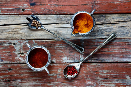 Rustic wooden background with spices selection in vintage metal cups. Top view.の写真素材