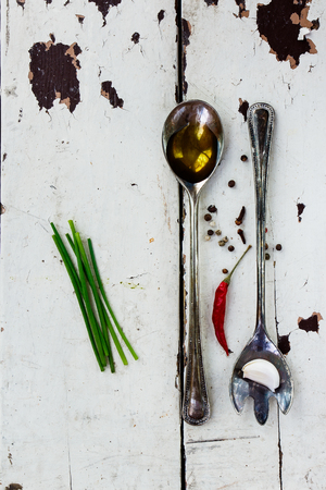 Olive oil in vintage spoon - herbs and spices selection on old white wooden backgroundの写真素材