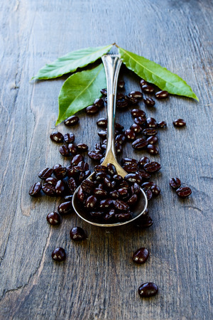 Coffee beans and vintage spoon on dark wooden background.の写真素材