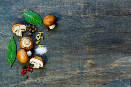 Top view of spices, herbs and fresh mushrooms on dark wooden table. Background with space for text.の写真素材