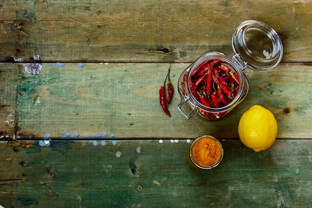 Top view of Red Hot Chili Peppers in glass jar over rustic wooden board - cooking or spicy food concept. Background with space for text.の写真素材