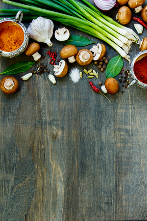 Top view of mushrooms with herbs and spices on dark wooden table. Background with space for text.の写真素材