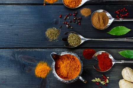 Close up of spices selection in old vintage cups and spoons over dark wooden background. Food or cooking concept. Top view.の写真素材