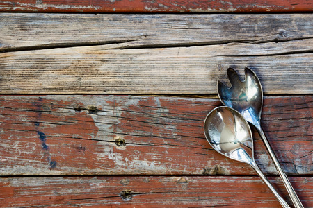 Top view of vintage metal serving spoons on rustic wooden background. Food or cooking concept.の写真素材
