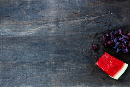 Fresh juicy watermelon and grapes on rustic wooden background.の写真素材