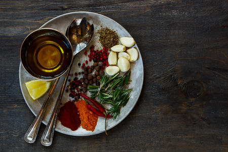 Top view of seasoning and spices on vintage metal plate over dark wooden background with space for text.の写真素材