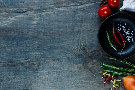 Food ingredients with vintage cast iron skillet on dark wooden background. Vegetarian food, health or cooking concept. Space for text.の写真素材