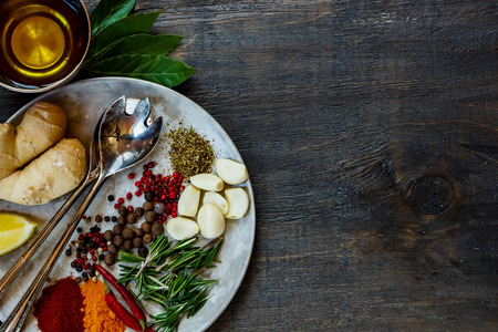 Colofrul fresh herbs and spices on old metal plate over dark wooden background with space for text. Top view. Food or cooking concept.の写真素材