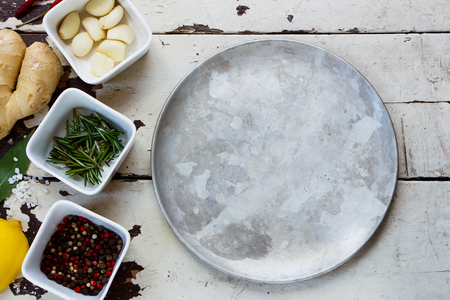 Fresh herbs and spices with old metal plate on white rustic background.の写真素材