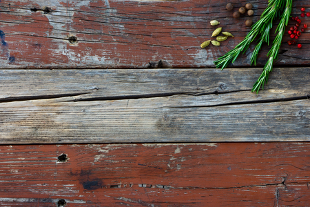 Fresh rosemary and aromatic spices on rustic wooden background with space for text.の写真素材