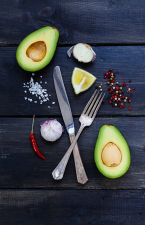 Spices, herbs selections and avocados on dark wooden board - healthy or vegetarian eating concept. Harvest or culinary background.の写真素材