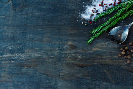 Top view of herbs and spices (rosemary, salt and pepper) on dark wooden background.の写真素材