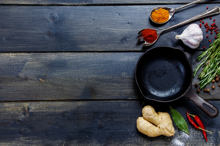 Old cast iron skillet and ingredients on rustic wooden background. Vegetarian food, health or cooking concept.の写真素材