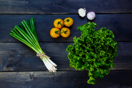Fresh ingredients for salad on dark wooden background - healthy or vegetarian eating concept.の写真素材