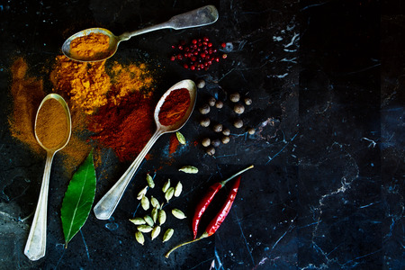 Close up of spices selection in old metal spoons on a stone background with space for text. Top view. Cooking, healthy eating.の写真素材