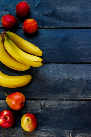 Fresh fruits on rustic wooden board. Healthy eating background with space for text.の写真素材