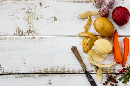 Vegetables for cooking on white wooden background. Vegetarian food, health or cooking concept. Rural still life from above with free text space.の写真素材