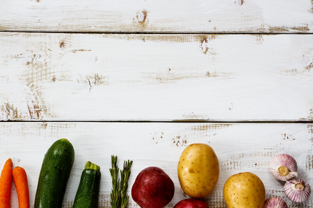 Organic ingredients for cooking on white wooden background with space for text. Vegetarian food, health or cooking concept.の写真素材