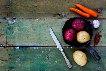 Fresh organic vegetables (potato, onion, carrot) ready for cooking. Health, vegetarian food or cooking concept.の写真素材