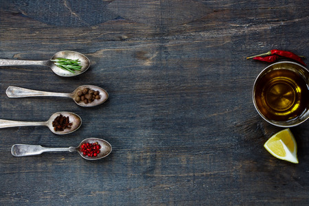 Spices and olive oil. Herbs and spices selection - old metal spoons and rustic wooden background. Cooking, food or health concept.の写真素材