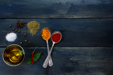 Healthy eating background - herbs and spices selection, old metal spoons and dark wooden background - cooking concept, top view.の写真素材