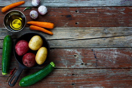 Fresh organic vegetables for cooking. Potato preparation over rustic wood.Food background. Healthy food from garden.の写真素材