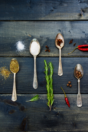 Food ingredients - herbs and spices, old metal spoons and dark wooden background - cooking, healthy eating.の写真素材