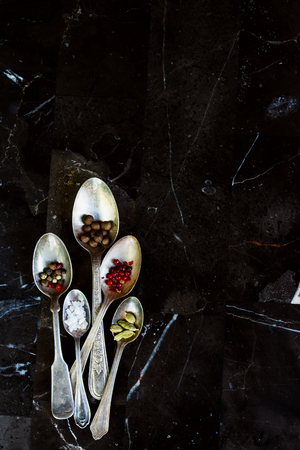 Mix of spices in old metal spoons on a stone background with space for text. Top view. Cooking, healthy eating.の写真素材