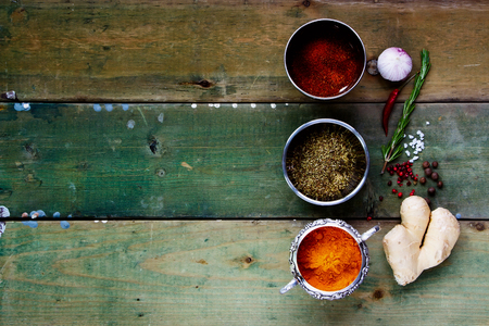 Spices on rustic wood. Herbs and spices selection - old metal cups and wooden background. Cooking, food or health concept. Space for textの写真素材