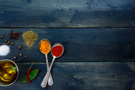 Herbs and spices selection, old metal spoons and dark wooden background - cooking, healthy eating. Top view.の写真素材