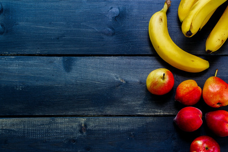 Healthy eating background with fresh fruits on rustic wooden board. Space for text.の写真素材