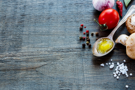 Tomatoes, olive oil and mushrooms on dark wooden background with space for text. Vegetarian food, health or cooking concept.の写真素材