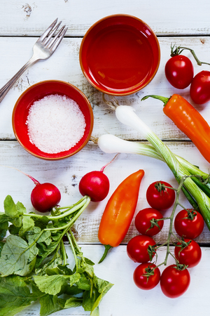 Fresh Ingredients of vegetable salad on white wooden background. Healthy or vegetarian eating concept.の写真素材