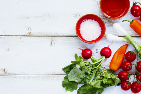 Background with Ingredients of Fresh vegetable salad on white wooden board. Healthy or vegetarian eating concept.の写真素材