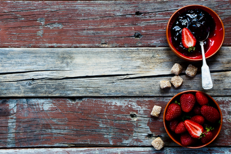 Strawberry jam in bowl on rustic wooden background with space for text.の写真素材