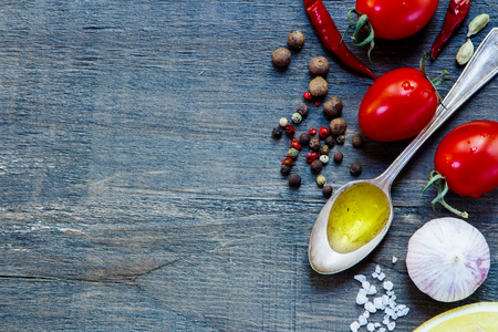 Close up of tomatoes with herbs and spices on dark wooden background with space for text. Vegetarian food, health or cooking concept.の写真素材