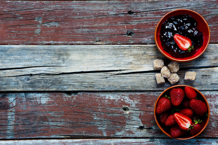 Top view of Strawberry jam in ceramic bowl on rustic wooden background.の写真素材