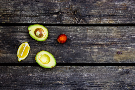 Organic avocados over rustic wooden background with space for text. Top view. Food or cooking concept.の写真素材