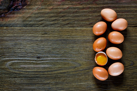 Food background with eggs and one yolk over rustic texture. Top view. Space for text.の写真素材