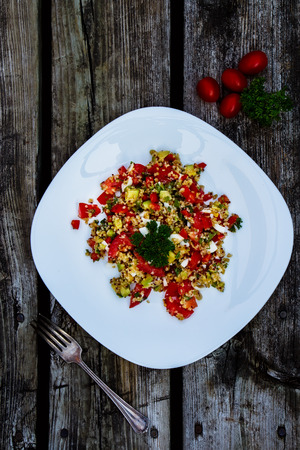 Fresh salad with avocado, quinoa and vegetables on rustic wooden background. Vegeterian food and health concept.の写真素材