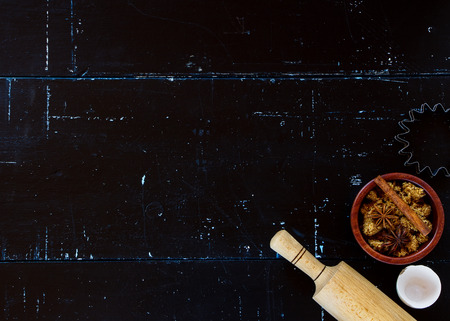 Baking ingredients with rolling pin and brown sugar on dark vintage background with space for text. Top view.の写真素材