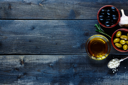 Olive Oil and Olives on dark wooden board. Healthy eating concept. Cooking background with space for text. Top view.の写真素材