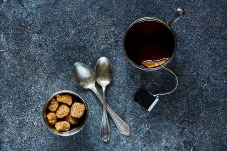 Vintage cup of tea with teabag over dark stone background. Top view.の写真素材