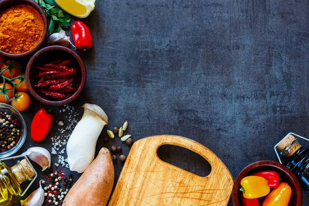 Healthy colorful farm vegetables and ingredients for tasty cooking on rustic background with space for text, border, top view.の写真素材