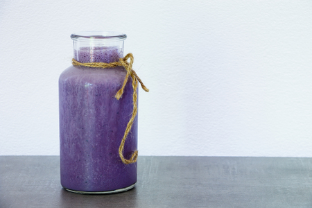 Freshly blended blueberry smoothie in glass jar. White background with space for text.の写真素材