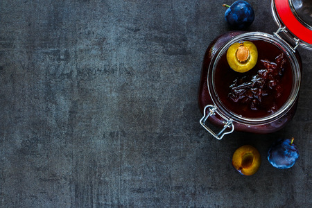 Dark food background with ingredients for making plum jam bassed on traditional recipe, top view, space for text.の写真素材