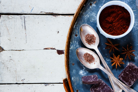Ingredients for hot chocolate with spices on old rusty iron background over rustic white wood table, top view, horizontal compositionの写真素材