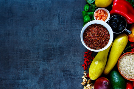Colorful vegetables, fruit, nuts, red rice, quinoa, spices, superfoods, herbs, condiment for vegan, gluten free, allergy-friendly, clean eating and raw diet. Vintage slate background and top viewの写真素材
